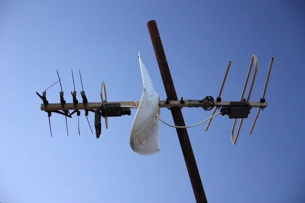 Old tv antenna isolated on blue sky
