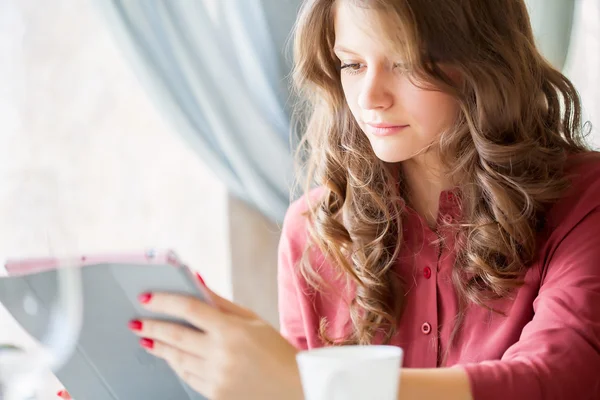 Jonge lachende vrouw drinkt koffie in een café — Stockfoto