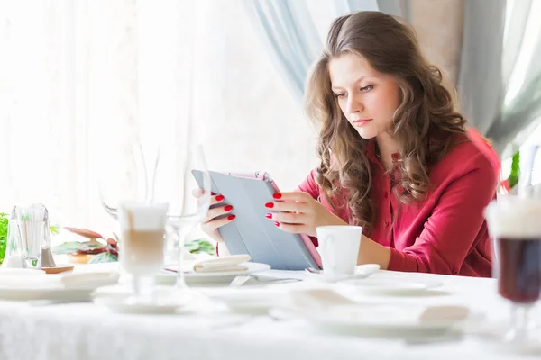 Young smiling woman is drinking coffee in a cafe — Stock Photo, Image