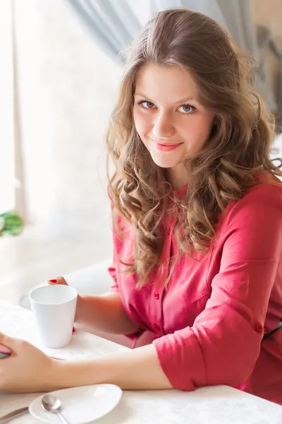 A woman in a restaurant is drinking coffee — Stock Photo, Image