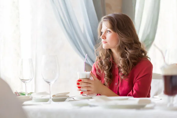 Eine Frau in einem Restaurant trinkt Kaffee — Stockfoto