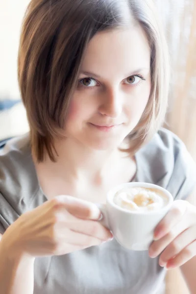 A woman in a restaurant is drinking coffee — Stock Photo, Image