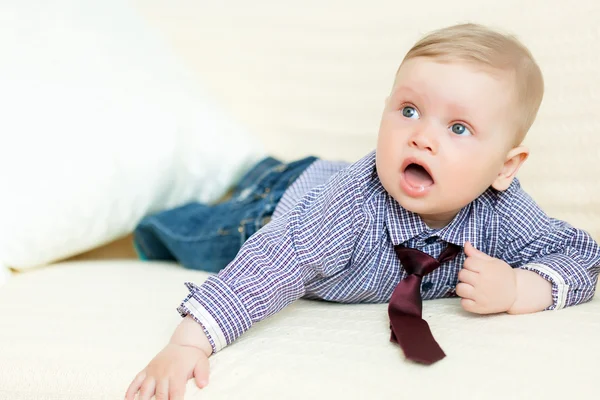 Boy in suit is lying on sofa — Stock Photo, Image