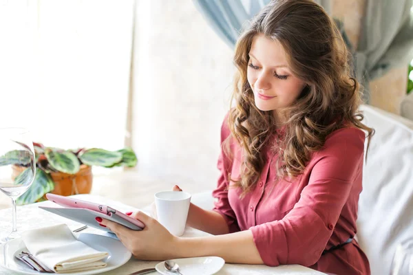 Jonge lachende vrouw drinkt koffie in een café — Stockfoto