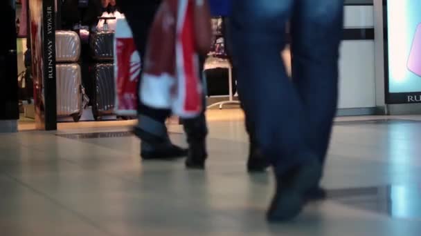 Ноги людей в аэропорту. Спикер информирует об изменении ворот — стоковое видео