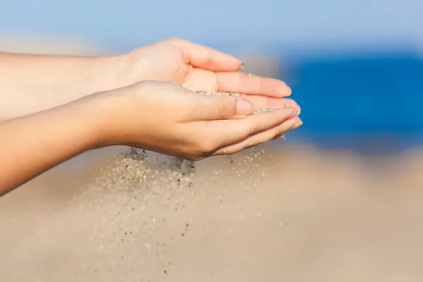 Vrouw met zand door middel van haar handen van vallen — Stockfoto