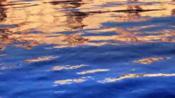 Puesta de sol naranja reflejada en el agua — Vídeo de stock