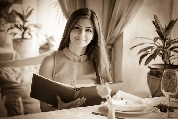 A woman in a restaurant with the menu in hands — Stock Photo, Image