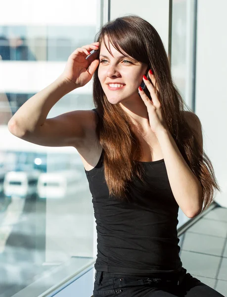 Vrouw gaat op mobiele telefoon in de luchthaven — Stockfoto