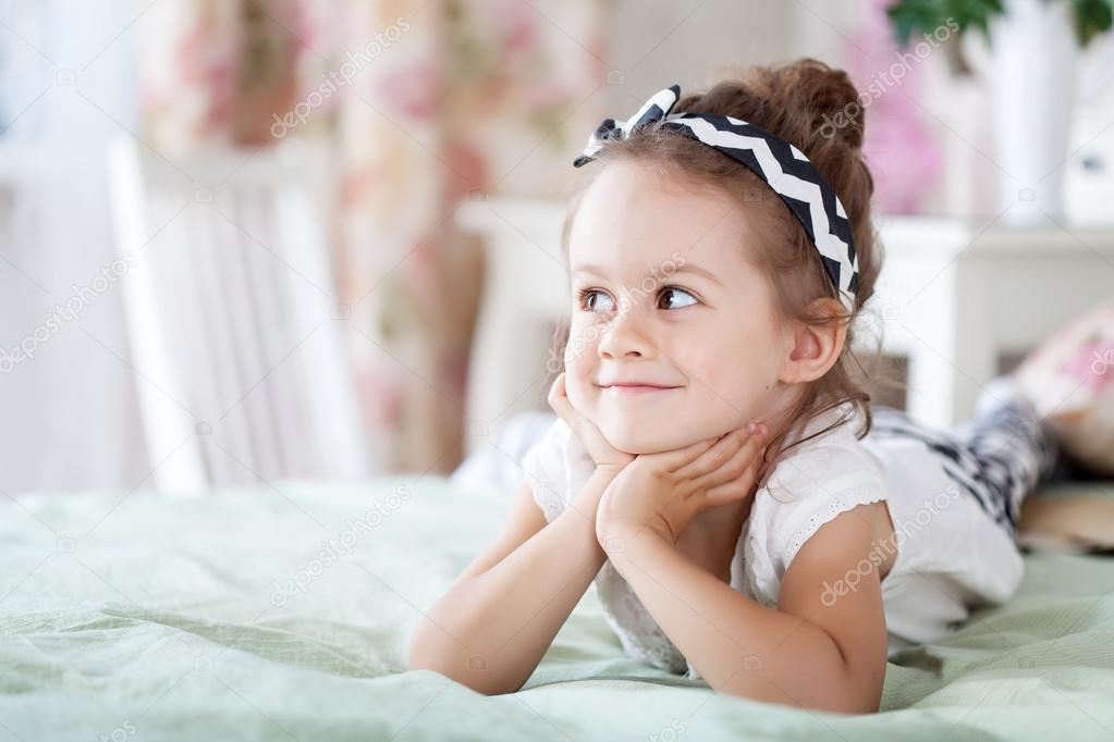 Girl is lying on the bed Stock Photo by ©orelphoto2 50367077