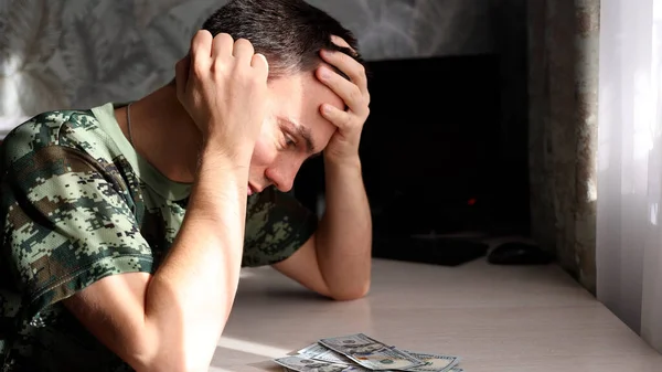 Uomo depresso contando banconote in dollari e sentendosi preoccupato per il problema finanziario. — Foto Stock