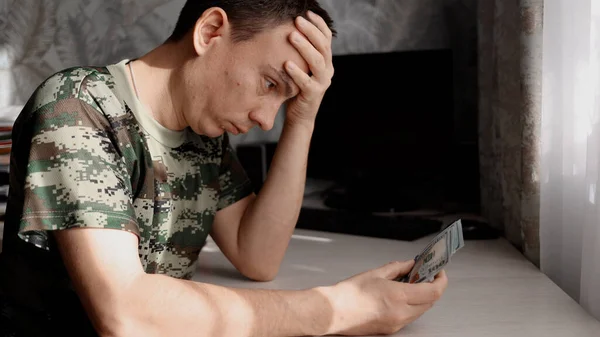 Uomo depresso contando banconote in dollari e sentendosi preoccupato per il problema finanziario. — Foto Stock