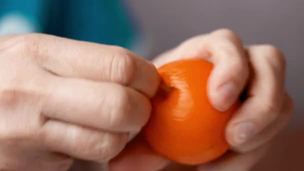 Närbild händer är peeling orange och välsmakande mandarin. — Stockvideo
