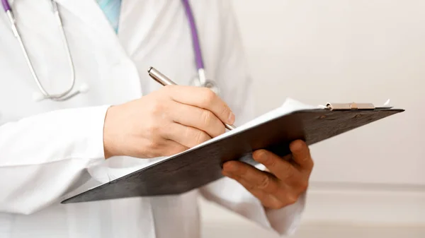 Dokter die patiëntenaantekeningen schrijft voor een medische test — Stockfoto