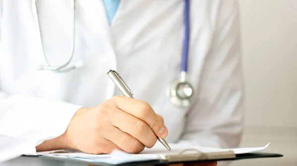 Dokter die patiëntenaantekeningen schrijft voor een medische test — Stockfoto