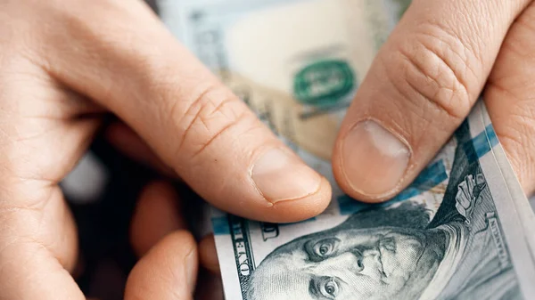 Handen tellen US Dollar rekeningen of contant betalen op geld achtergrond. — Stockfoto