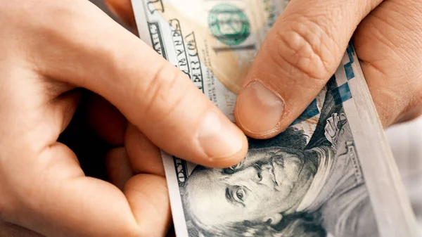 Руки, считая счета в долларах США или оплачивая наличными на денежном фоне. — стоковое фото