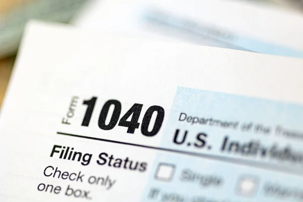 Formulário de declaração de imposto de renda individual US 1040 com notas de 100 dólares. — Fotografia de Stock