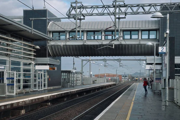 Big train station in Edinburgh and a woman from behind waiting for a train — Stock Photo, Image
