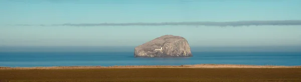 Um grande panorama da costa marítima e ilha de rocha com um farol — Fotografia de Stock