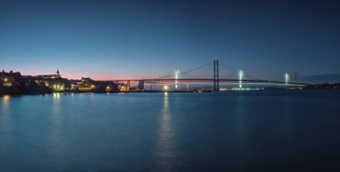 Gün batımına karşı iki köprü Gökyüzü ve şehir seti ışıklarla doluyor