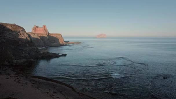 Les ruines d'un vieux château debout sur une falaise sur le rivage de la baie de la mer au coucher du soleil — Video