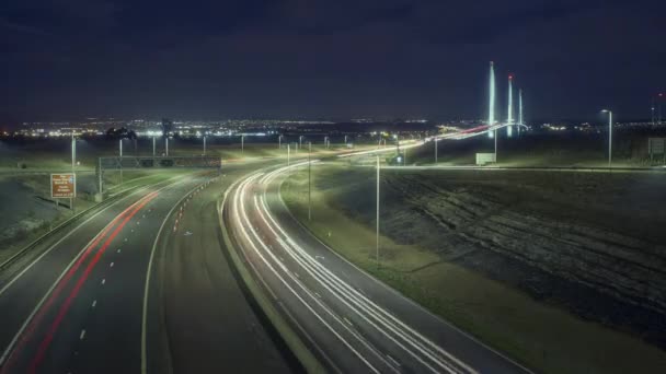 Včas na silnici vedoucí k velkému mostu a světla z aut v noci — Stock video