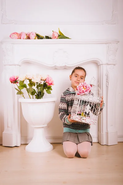 Little girl with flowers and toys — Stock Photo, Image
