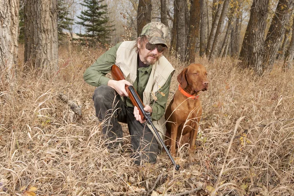Jägaren och hans hund i skogen — Stockfoto