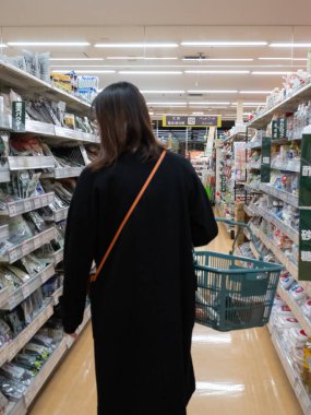 Tokyo, Japonya - 19.11.19: Genç bir Japon bayan süpermarketten alışveriş yapıyor