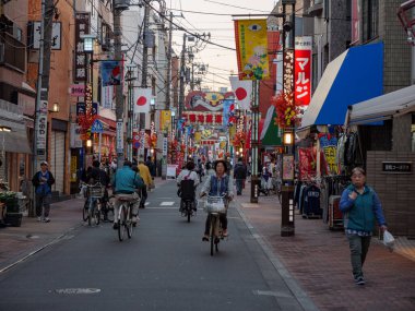 Tokyo, Japonya - 18.11.19: Emekliler Sugamo üzerinden ana caddede bisiklet sürüyorlar.