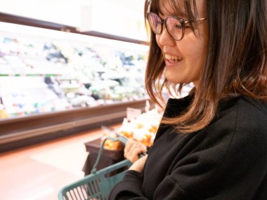 Genç bir Japon kadın bir Japon süpermarketinden alışveriş yapıyor..