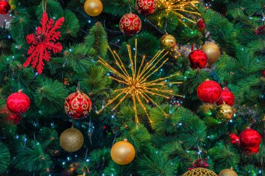 Yeşil Noel ağacında farklı kırmızı ve sarı çok renkli yeni yıl süslemeleri