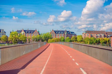 Demiryollarından geçen yaya ve bisiklet köprüsü konut binalarına doğru gidiyor. Kopenhag, Danimarka