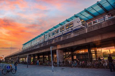 Metro treni gün batımına karşı M1 hattı DR Byen 'in hızlı ulaşım istasyonunda duruyor. Kopenhag, Danimarka