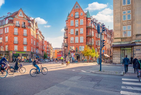 旧レンガ造りの家 多くの自転車 歩行者やコペンハーゲン デンマークの車で主要な通りのゲスト団 ストック写真