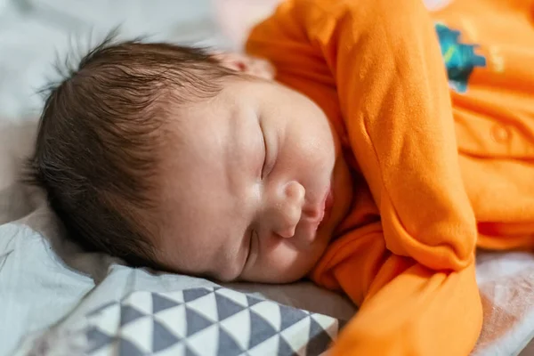 橙色紧闭的新生儿睡在床上 — 图库照片