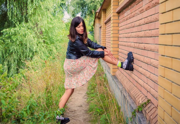 Een Jong Brunette Meisje Staat Met Haar Voet Een Bakstenen — Stockfoto