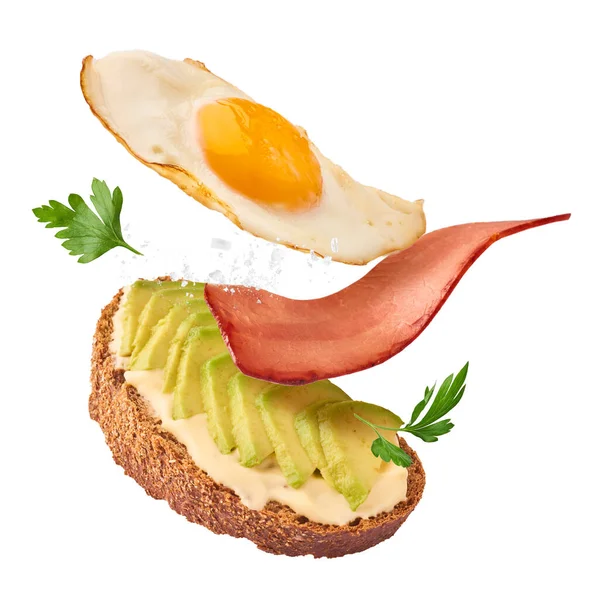 Verse Heerlijke Zelfgemaakte Sandwich Met Avocado Geroosterd Spek Vallen Lucht — Stockfoto