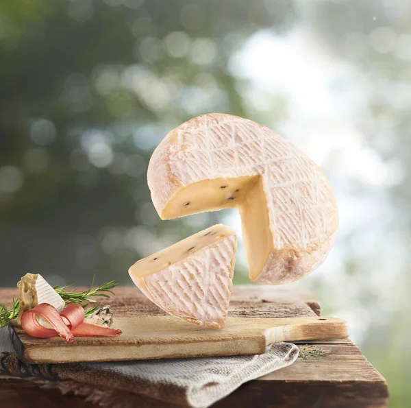新鮮なおいしいチーズは 木製のテーブルの上に空中に落ちます焦点を当てたボケの背景 食品の浮遊概念 高品質の画像 — ストック写真
