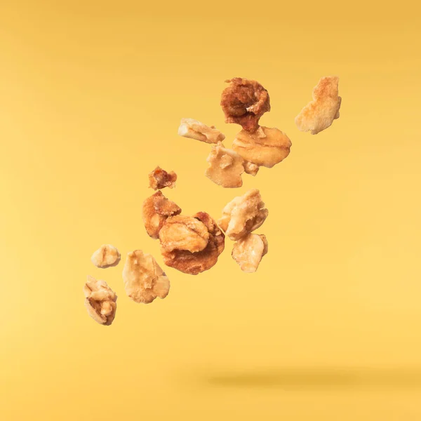 新鲜的格拉诺拉片片在黄色背景的空气中飘扬 食物零重力的概念 高分辨率图像 — 图库照片
