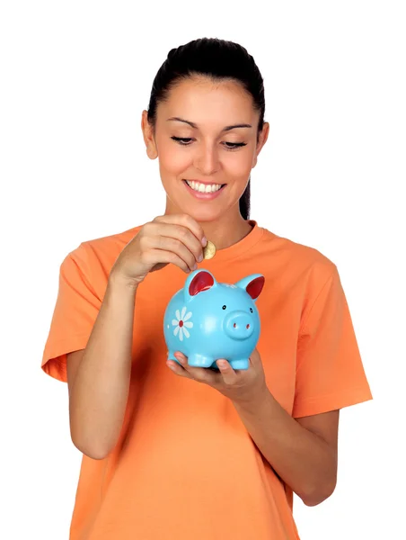 Pretty brunette woman inserting a coin in a piggy-bank — Stock Photo, Image