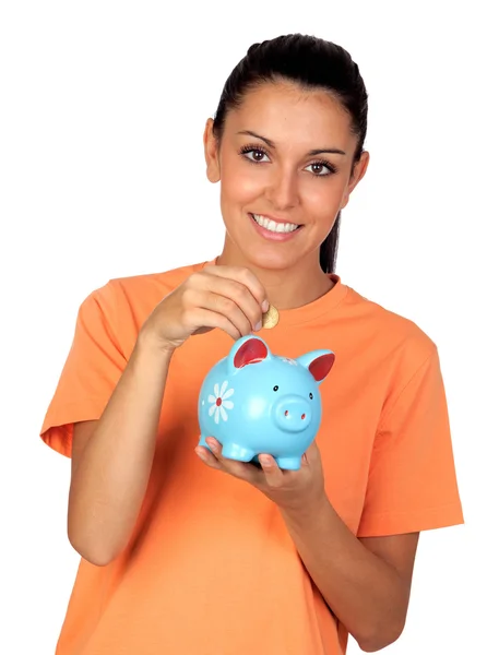 Mooie brunette vrouw invoegen van een munt in een piggy-bank — Stockfoto