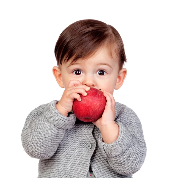 Adorable baby girl eating a red apple Stock Photo