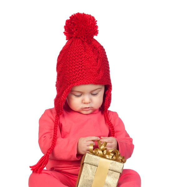 Menina bebê com chapéu de lã procurando um presente — Fotografia de Stock