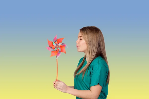 Menina engraçada soprando um pinwheel — Fotografia de Stock