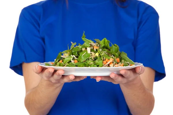 Anonymous hands offering a plate of vegetables — Stock Photo, Image