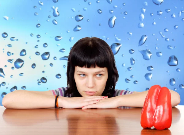 Pensive girl lookin a red pepper — Stock Photo, Image