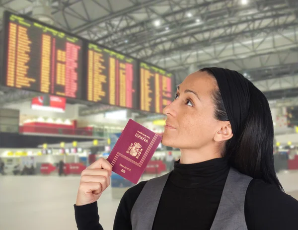 Hermosa mujer con pasaporte mirando el panel —  Fotos de Stock