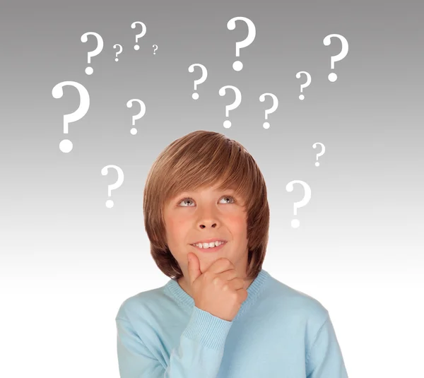 Doubtful preteen boy with many question symbols — Stock Photo, Image